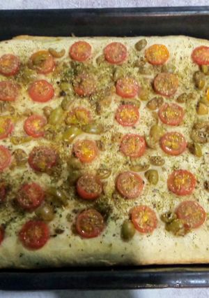 Una foto de Focaccia con tomates cherry, aceitunas y orégano 🇮🇹