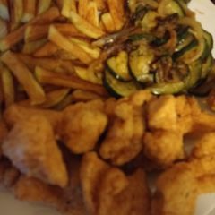 A picture of Fried Cajun chicken with homemade fries and courgette.