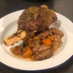 A picture of Slow cooked venison shank with chipolatas.