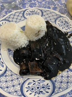 Una foto de Calamares en su tinta con arroz blanco