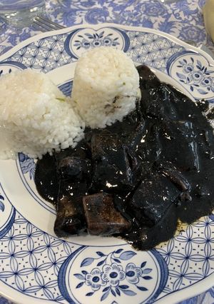 Una foto de Calamares en su tinta con arroz blanco