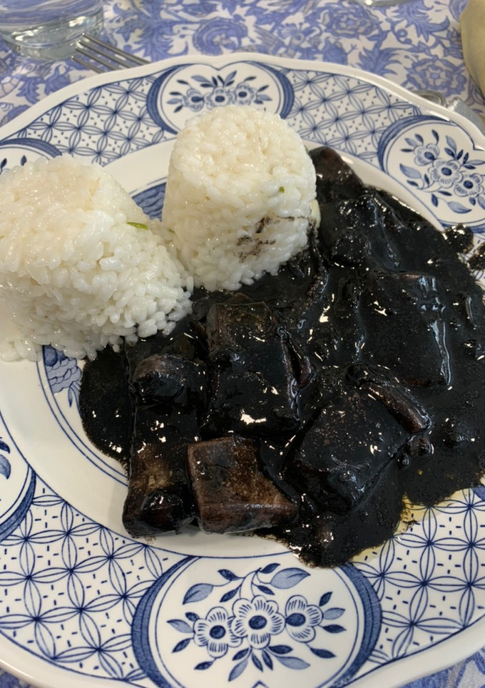 Una foto de Calamares en su tinta con arroz blanco
