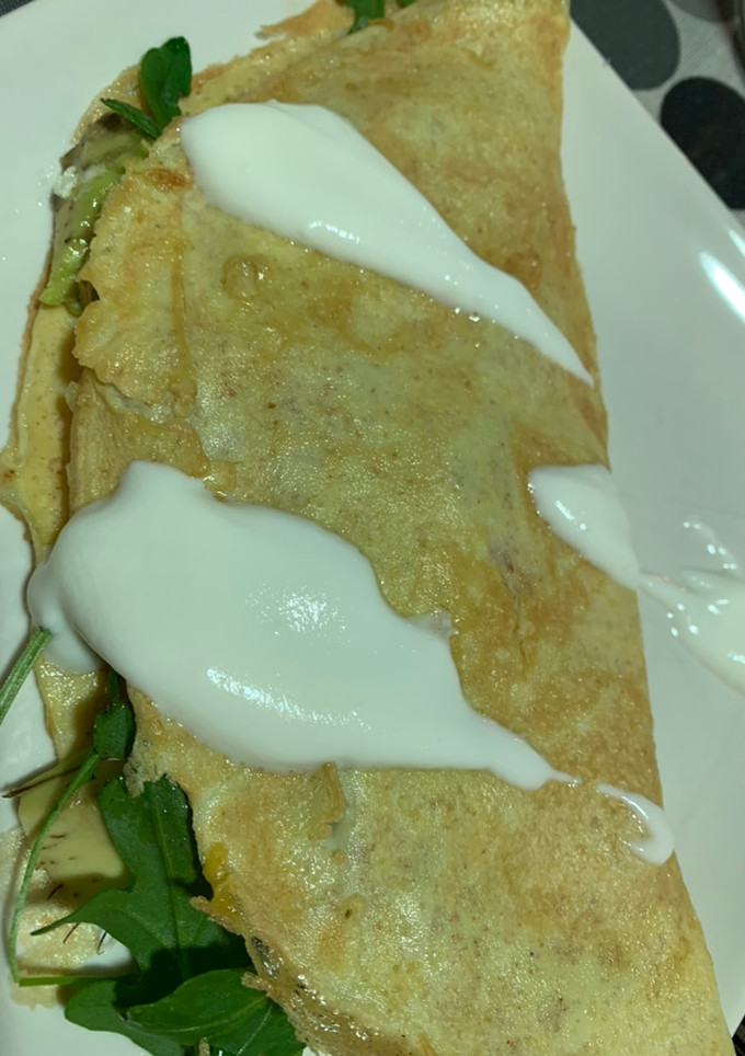 Una foto de Tortilla media luna con tomate, aguacate, rúcula y queso. Topping de salsa de yogur