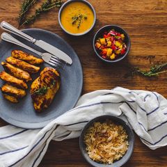 A picture of Honey & Mustard marinated Chicken with Sautéed Onion Rice, Mango Salsa and a honey & mustard sauce.