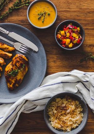 A picture of Honey & Mustard marinated Chicken with Sautéed Onion Rice, Mango Salsa and a honey & mustard sauce.