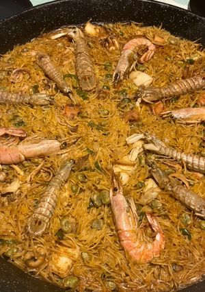 Una foto de Fideuà de mariscos, con sepia sucia, galeras y gambones