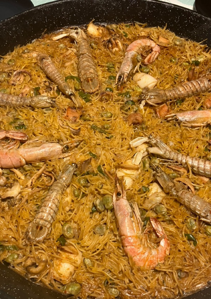 Una foto de Fideuà de mariscos, con sepia sucia, galeras y gambones