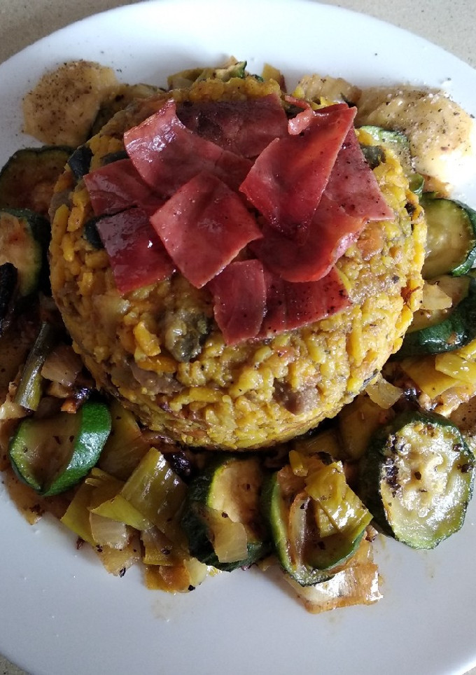 Una foto de Timbal de arroz con corona de revuelto de verduras, con pollo