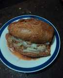 Torta bañada en jitomate,  carnitas de cerdo con cebolla desflemada estilo las Correa de San Diego