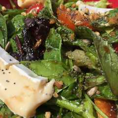 Una foto de Ensalada de verdes, semillas, tomate, queso brie y croutons