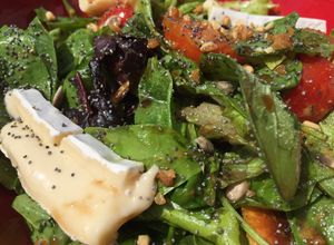 Una foto de Ensalada de verdes, semillas, tomate, queso brie y croutons