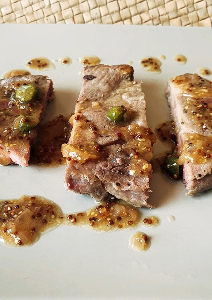 Una foto de Chuleta de cerdo, salsa de mostaza y encurtidos