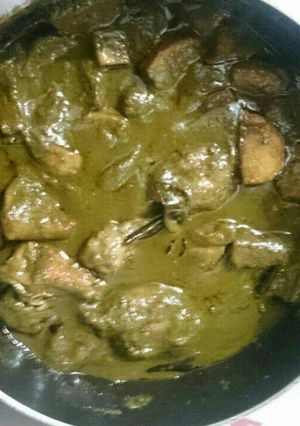 A picture of Green chicken with fried potatoes.