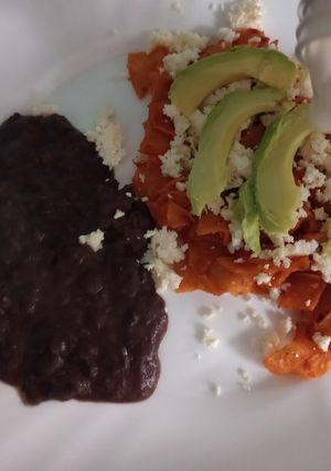 Una foto de Chilaquiles rojos con queso y aguacate para la mañana
