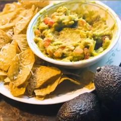 A picture of Guacamole salsa with nachos.