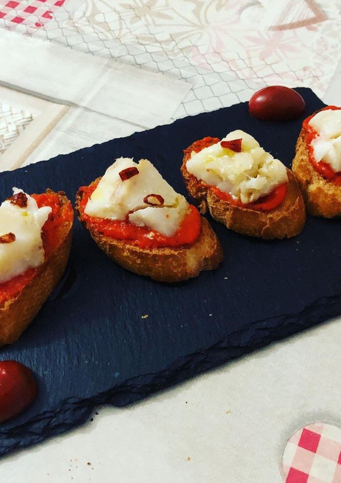 Una foto de Bacalao confitado con crema de pimiento morrón y guindilla cayena y el otro pincho con pil pil