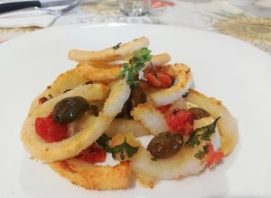 Foto di Anelli di Calamari al Forno con Pomodori Freschi, Pangrattato, Olive Verde, Prezzemolo e Aglio