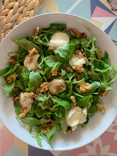 Una foto de Ensalada de canónigos y rúcula con queso de cabra, nueces, pipas y vinagreta de miel