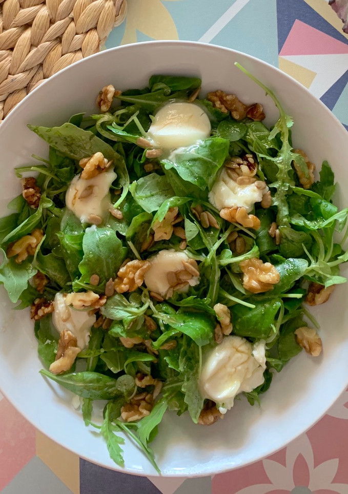Una foto de Ensalada de canónigos y rúcula con queso de cabra, nueces, pipas y vinagreta de miel