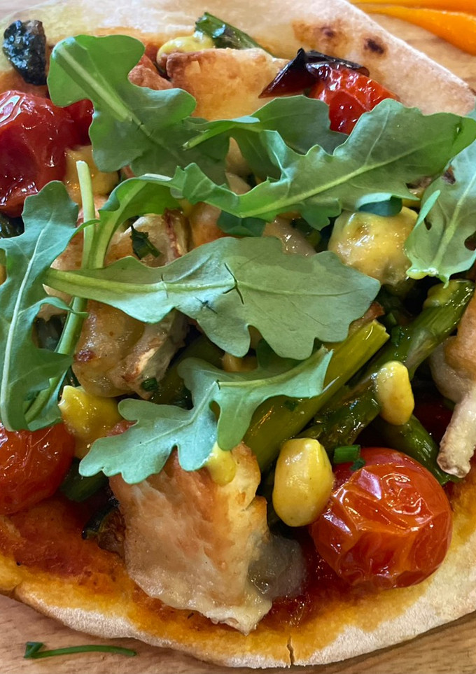 Una foto de Pizza de calabacín, trigueros, cherry y rulo de cabra