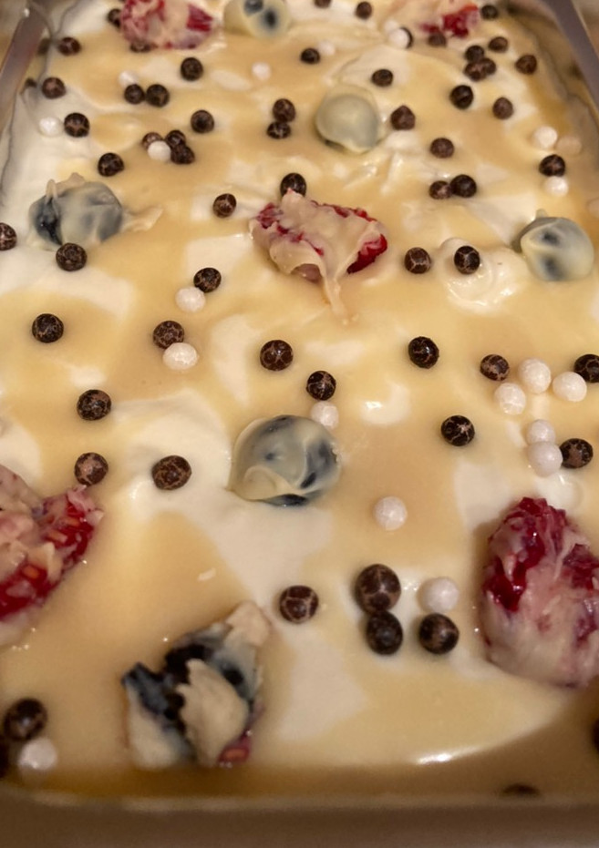 Una foto de Helado de chocolate blanco con frutos rojos bañados en chocolate blanco y sirope de chocolate blanco