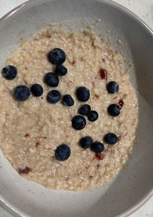 A picture of Porridge with blueberries and strawberry jam.
