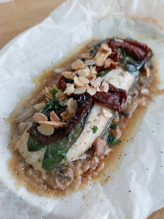 Una foto de Bacalao en papillote con cebolla caramelizada, champiñones y tomate seco