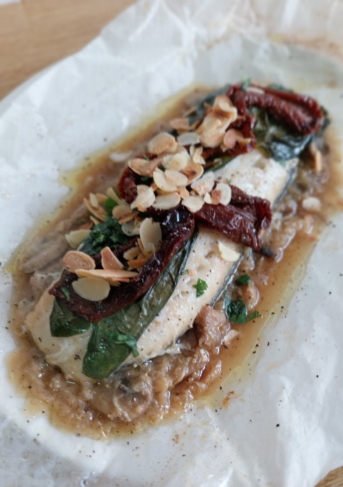 Una foto de Bacalao en papillote con cebolla caramelizada, champiñones y tomate seco