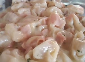 Una foto de Sorrentinos con salsa blanca casera y jamón en cubitos