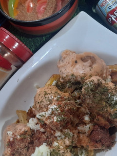 A picture of Nuggfries loaded with cheese sauce.