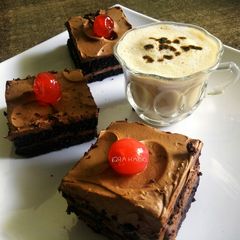 A picture of Chocolate squares with hot coffee.
