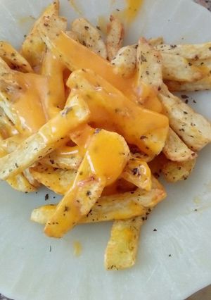 Una foto de Papas fritas con salsa cheddar saborizada con panceta