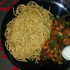 A picture of Jollof spaghetti and vegetable sauce with turkey.