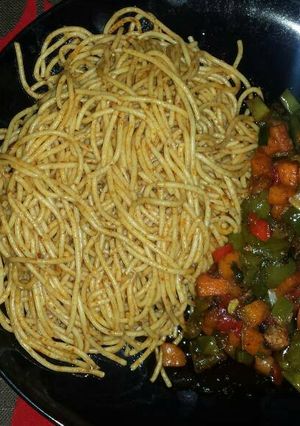 A picture of Jollof spaghetti and vegetable sauce with turkey.