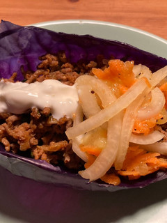 Una foto de Taquitos de col morada con ensalada de kiwi
