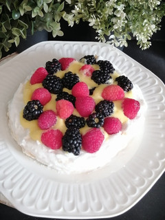 Una foto de Pavlova con crema de naranja y frutos rojos