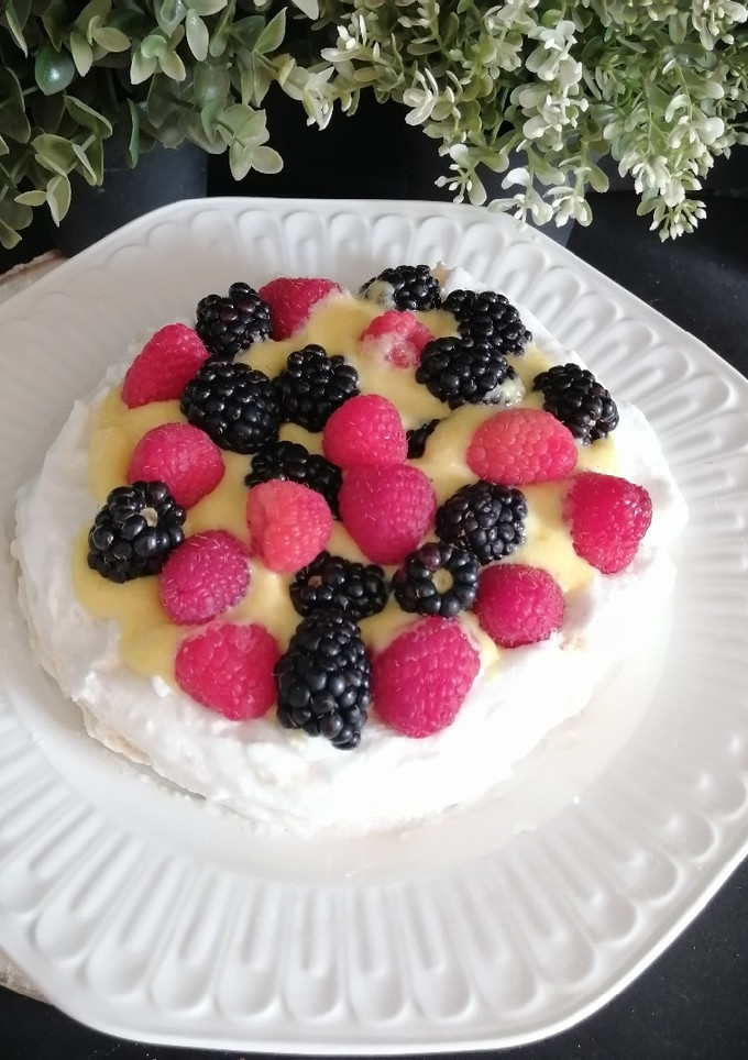 Una foto de Pavlova con crema de naranja y frutos rojos