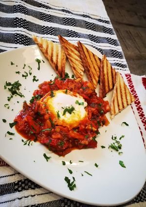 O poză a rețetei Shakshuka sau ouă poșate în sos de roșii.