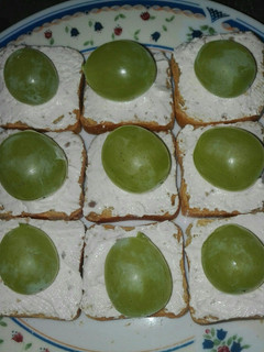 Una foto de Tostas de pan tostado con mousse de queso con nueces y uvas