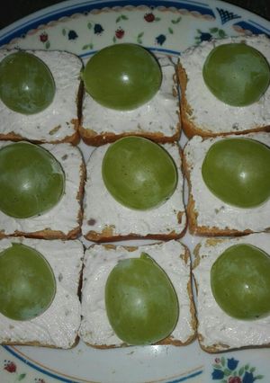 Una foto de Tostas de pan tostado con mousse de queso con nueces y uvas