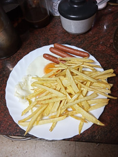 Una foto de Huevos fritos con papas fritas y salchichas