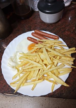 Una foto de Huevos fritos con papas fritas y salchichas