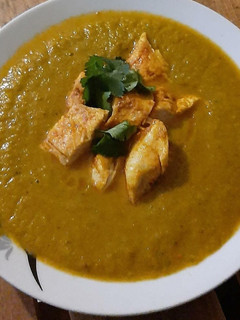A picture of Indian spiced veg soup with grilled chicken fillet.
