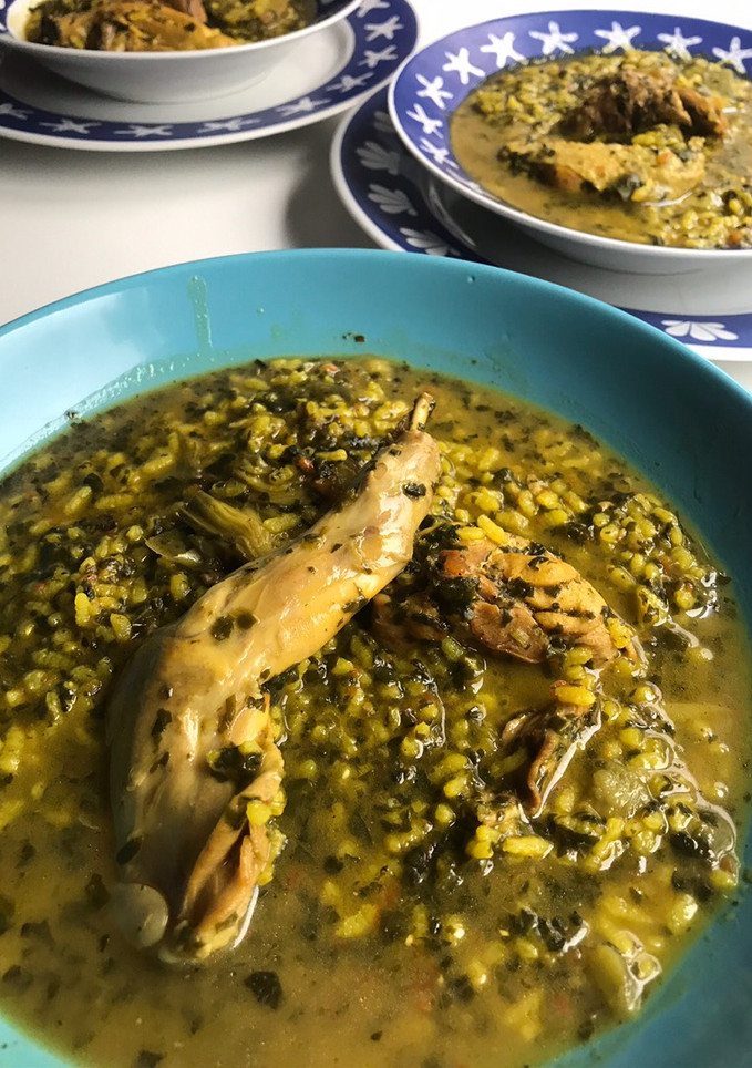 Una foto de Arroz caldoso de pollo y conejo, con espinacas y alcachofas