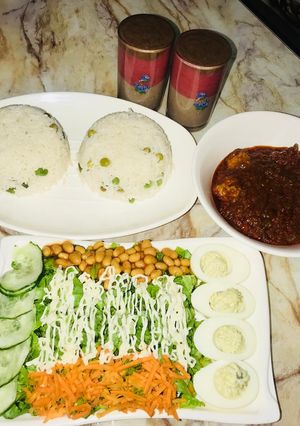 A picture of White rice wt chicken ball stew &salad wt devilled eggs.