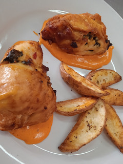 Una foto de Suprema rellena de espinaca con salsa de morrón