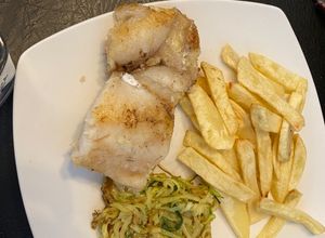 Una foto de Merluza austral a la mantequilla con fideo de zapallo italiano y papas fritas