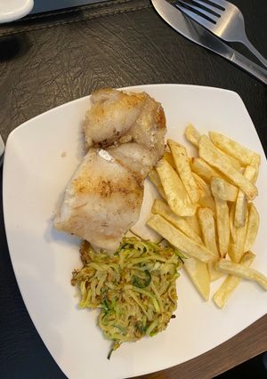Una foto de Merluza austral a la mantequilla con fideo de zapallo italiano y papas fritas