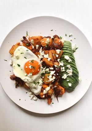 Una foto de Hash de patatas y huevo con aguacate y feta