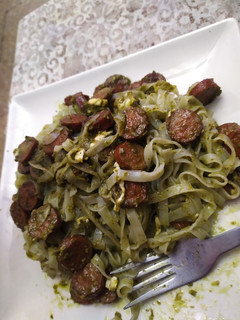 Una foto de Tallarines con salsa de pesto, salchichas y queso de cabra